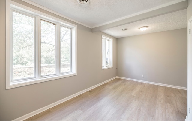 empty room featuring a textured ceiling and light hardwood / wood-style floors