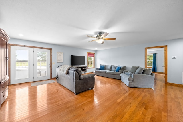 living room featuring ceiling fan, light hardwood / wood-style floors, and a healthy amount of sunlight