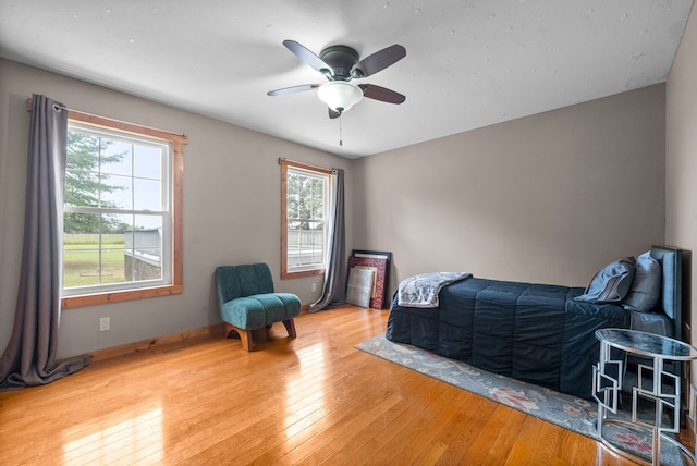 bedroom with light hardwood / wood-style floors and ceiling fan