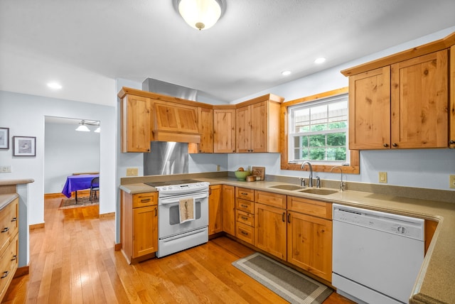 kitchen with light wood-type flooring, white appliances, sink, and custom exhaust hood