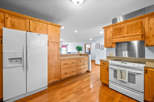 kitchen with white appliances and light hardwood / wood-style flooring