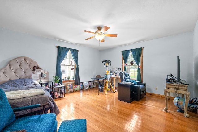 bedroom with wood-type flooring, multiple windows, and ceiling fan