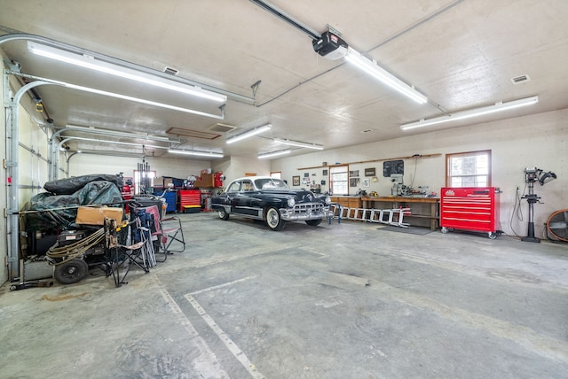 garage featuring a garage door opener and a workshop area