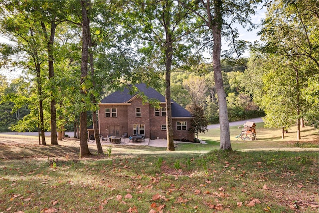 back of house featuring a lawn and a patio area