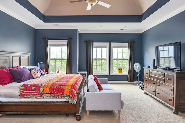 bedroom with ceiling fan, light colored carpet, a tray ceiling, and crown molding