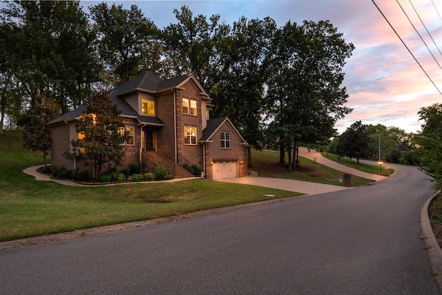 view of front of home with a garage and a lawn