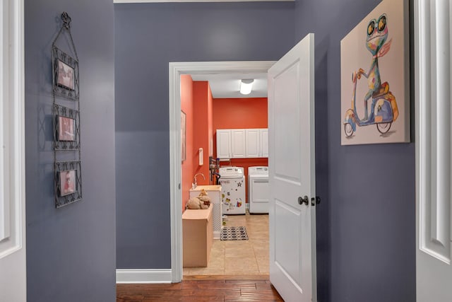 corridor with light wood-type flooring and washer and clothes dryer