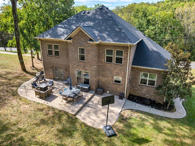 rear view of house with outdoor lounge area, a lawn, and a patio