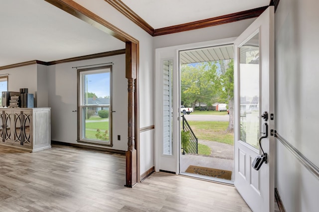 foyer with crown molding and light hardwood / wood-style floors