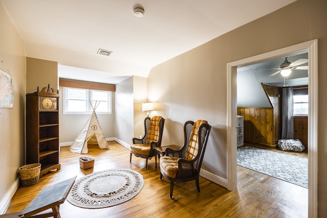 sitting room with ceiling fan, lofted ceiling, and hardwood / wood-style floors