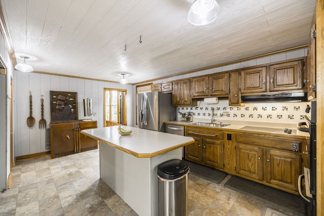 kitchen featuring sink, tasteful backsplash, stainless steel appliances, a center island, and crown molding