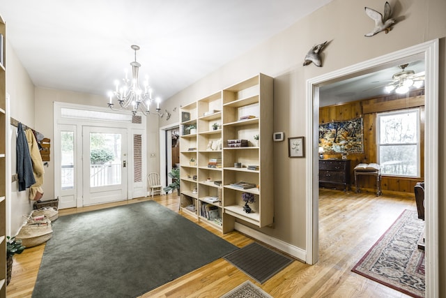 foyer with ceiling fan with notable chandelier and wood-type flooring