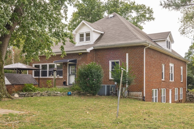 back of property featuring a gazebo, a lawn, and central AC