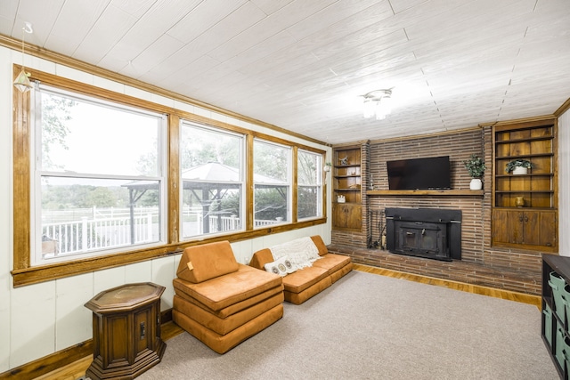 living room featuring a brick fireplace, wood-type flooring, a healthy amount of sunlight, and built in features