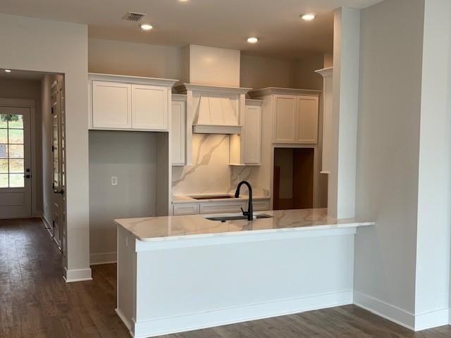 kitchen featuring baseboards, white cabinetry, light stone countertops, and dark wood-style floors