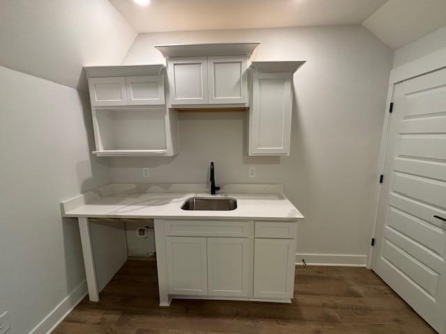 kitchen with lofted ceiling, baseboards, a sink, and dark wood-style flooring