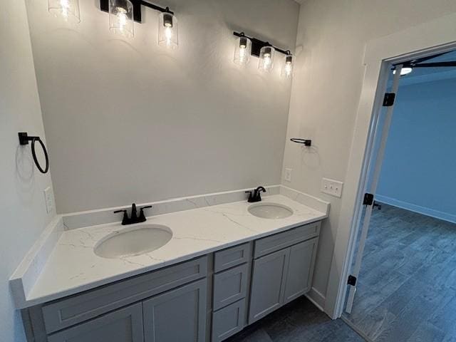 bathroom featuring wood finished floors, a sink, and double vanity