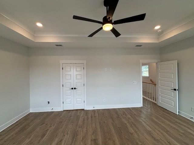 spare room featuring ornamental molding, wood finished floors, and a raised ceiling