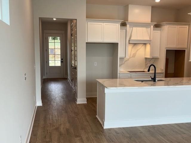 kitchen with white cabinets, baseboards, dark wood-style flooring, and a sink