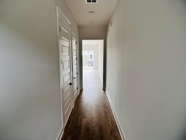 corridor with visible vents, baseboards, and wood finished floors
