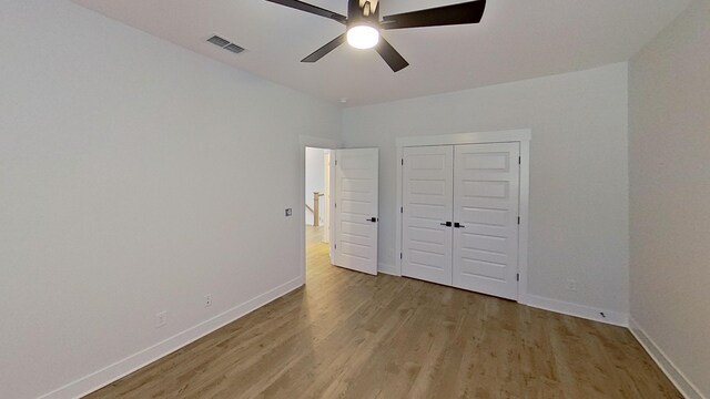 unfurnished bedroom featuring light wood-type flooring, visible vents, a ceiling fan, and baseboards
