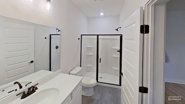 full bath with recessed lighting, a shower stall, wood finished floors, toilet, and vanity