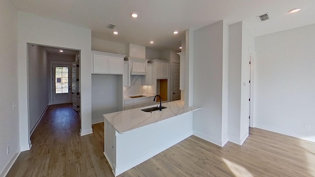 657 Gustaf Dr, Whites Creek, TN 37189 - kitchen featuring a sink, white cabinetry, light wood-style flooring, a peninsula, and baseboards