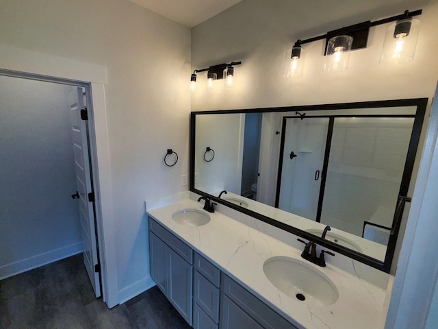bathroom featuring baseboards, a sink, and double vanity