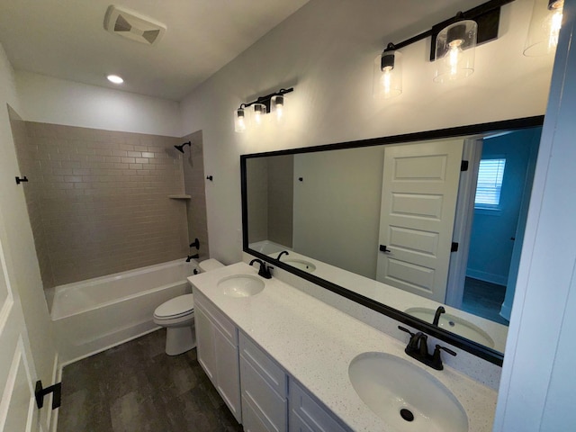 full bathroom featuring washtub / shower combination, toilet, and a sink
