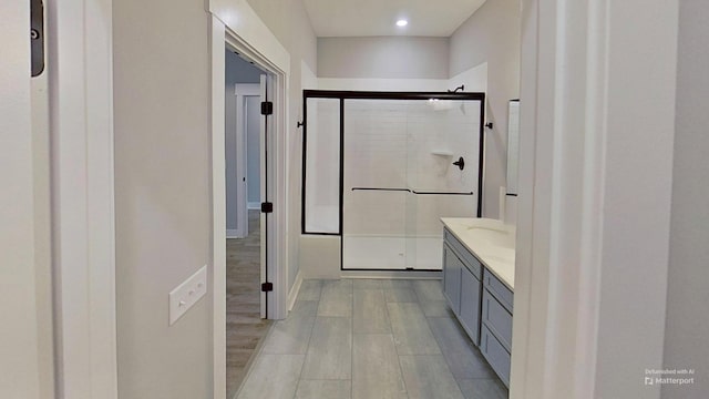 full bath featuring a stall shower, wood finished floors, and vanity