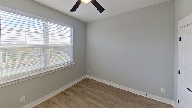 empty room featuring baseboards, light wood-style floors, and a ceiling fan