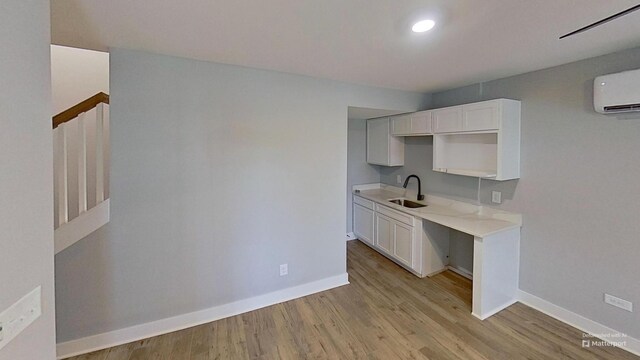 661 Gustaf Dr, Whites Creek, TN 37189 - kitchen with a sink, a wall mounted air conditioner, baseboards, light wood-style floors, and light countertops