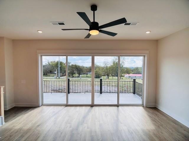 empty room featuring baseboards, plenty of natural light, wood finished floors, and recessed lighting