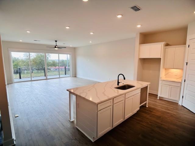 kitchen with a sink, ceiling fan, dark wood finished floors, a kitchen island with sink, and recessed lighting