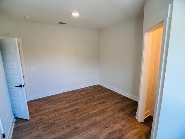 unfurnished room with dark wood-style flooring and baseboards