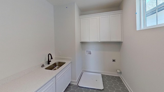 laundry area featuring electric dryer hookup, washer hookup, cabinet space, baseboards, and dark tile patterned floors