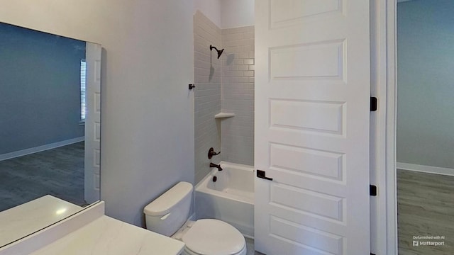 full bath featuring toilet, shower / washtub combination, and baseboards