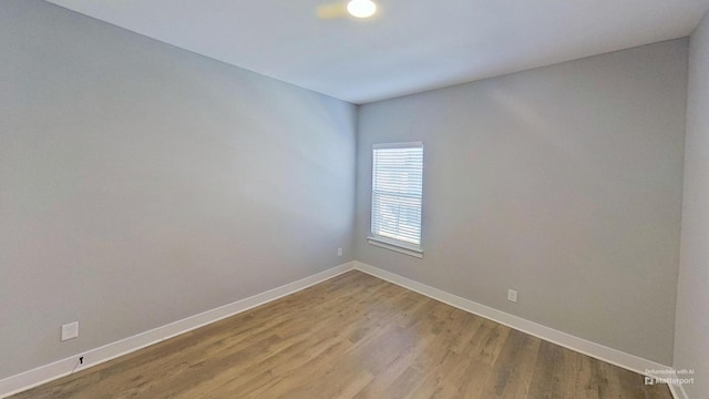 empty room with baseboards and light wood-style floors