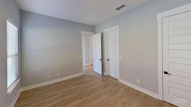 unfurnished bedroom with light wood finished floors and baseboards