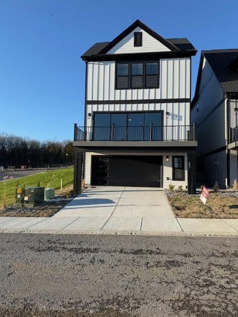 view of front of home featuring a balcony, driveway, and a garage
