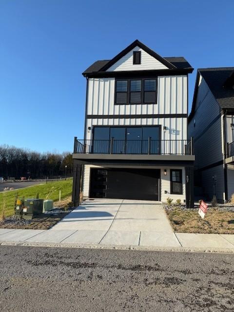 view of front facade with a balcony, an attached garage, and concrete driveway