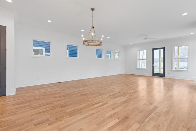 unfurnished living room featuring light wood-type flooring, ceiling fan with notable chandelier, and ornamental molding