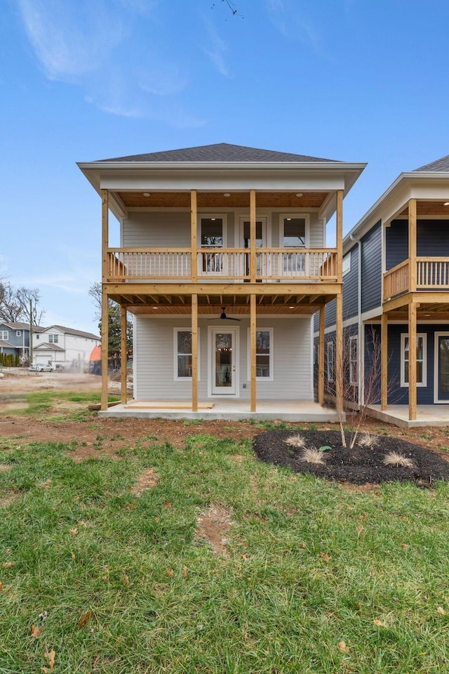 rear view of property with a balcony, a yard, and a patio