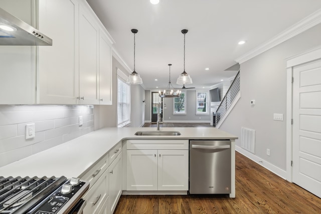 kitchen with appliances with stainless steel finishes, white cabinets, kitchen peninsula, dark hardwood / wood-style flooring, and wall chimney range hood