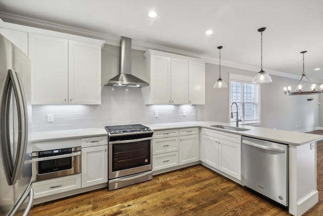 kitchen with sink, kitchen peninsula, decorative light fixtures, wall chimney exhaust hood, and appliances with stainless steel finishes