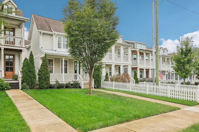 view of front of home with a front yard, a balcony, and a porch