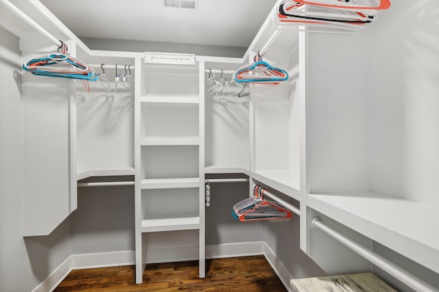 spacious closet with dark hardwood / wood-style flooring