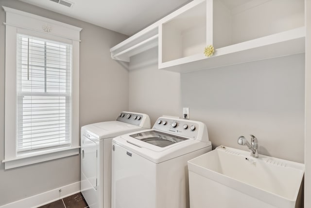 laundry room with sink, washer and dryer, and dark tile patterned floors