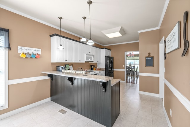 kitchen with pendant lighting, white cabinetry, kitchen peninsula, a kitchen bar, and black refrigerator with ice dispenser