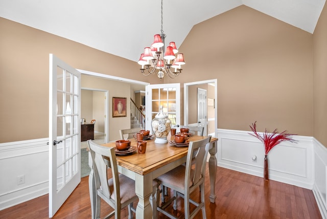 dining space featuring lofted ceiling, hardwood / wood-style floors, a chandelier, and french doors